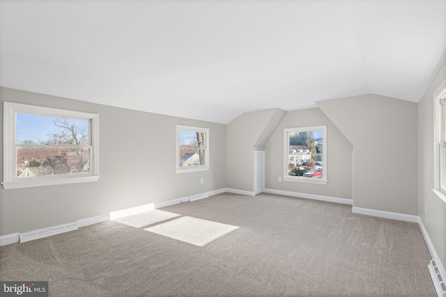 bonus room featuring vaulted ceiling, a wealth of natural light, and light carpet