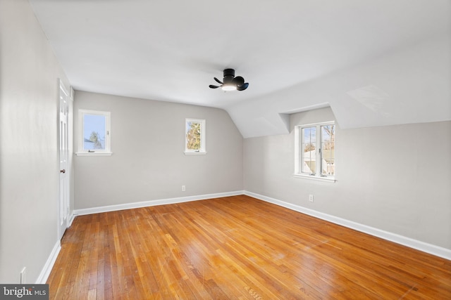 bonus room with wood-type flooring, vaulted ceiling, and a healthy amount of sunlight