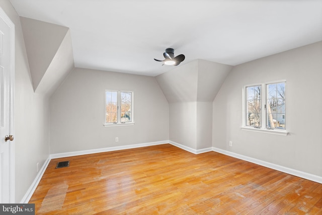 additional living space featuring ceiling fan, vaulted ceiling, plenty of natural light, and light hardwood / wood-style floors