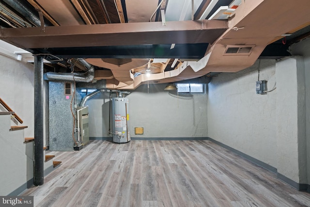 basement featuring heating unit, wood-type flooring, and gas water heater