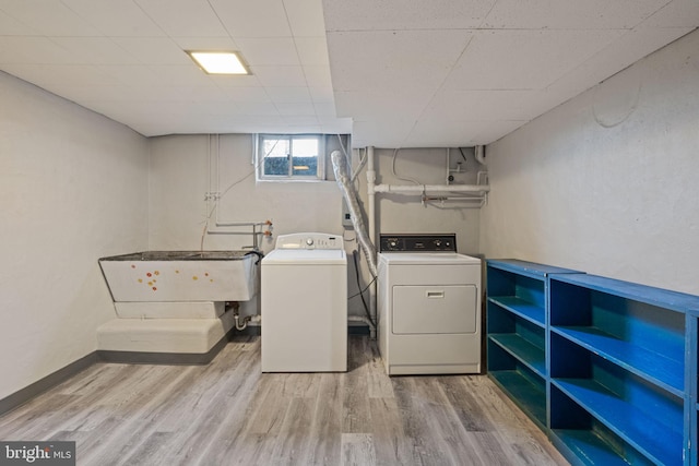 washroom with washer and dryer and light hardwood / wood-style flooring