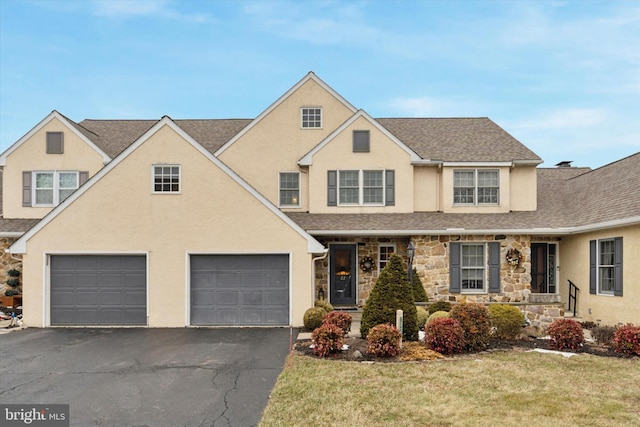 traditional-style house with aphalt driveway, roof with shingles, stucco siding, a front yard, and stone siding