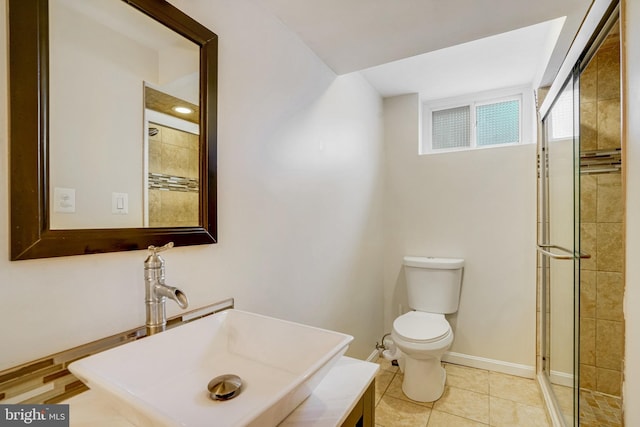 bathroom with tile patterned floors, toilet, a shower with shower door, and sink