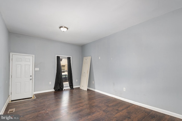 empty room with dark hardwood / wood-style flooring