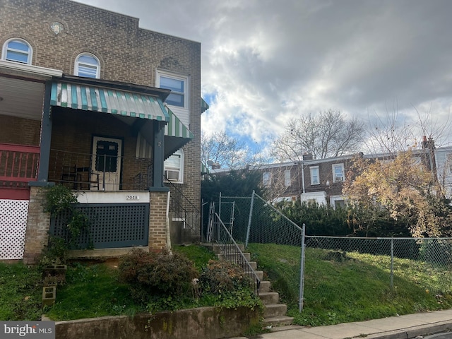 view of side of property featuring covered porch and a lawn