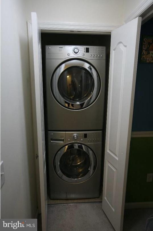 laundry area featuring stacked washer / dryer