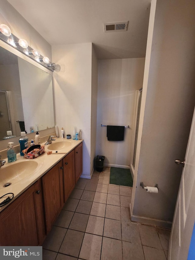 bathroom with tile patterned flooring, walk in shower, and vanity