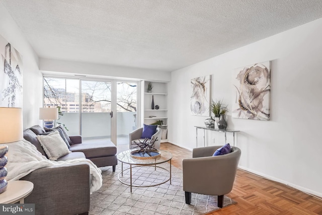 living room featuring a textured ceiling and light parquet floors