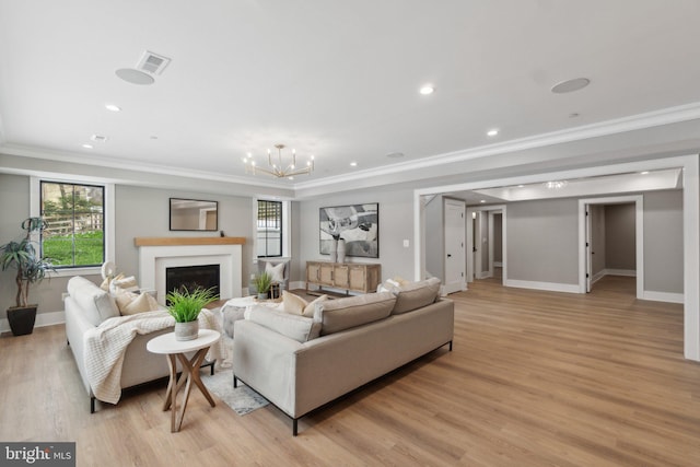 living room featuring an inviting chandelier, ornamental molding, and light hardwood / wood-style flooring