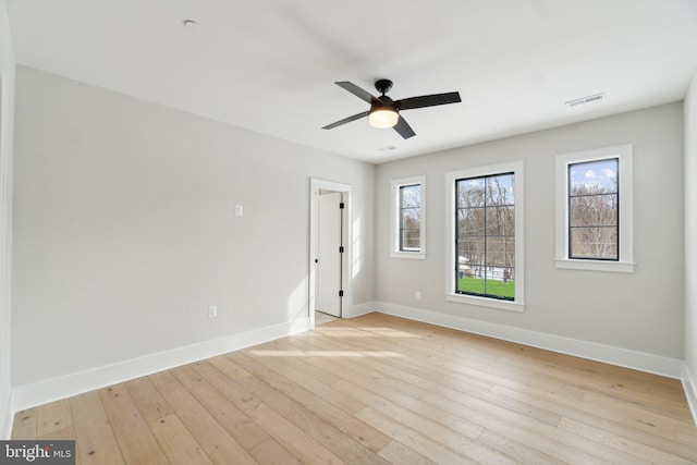 empty room with ceiling fan and light hardwood / wood-style flooring