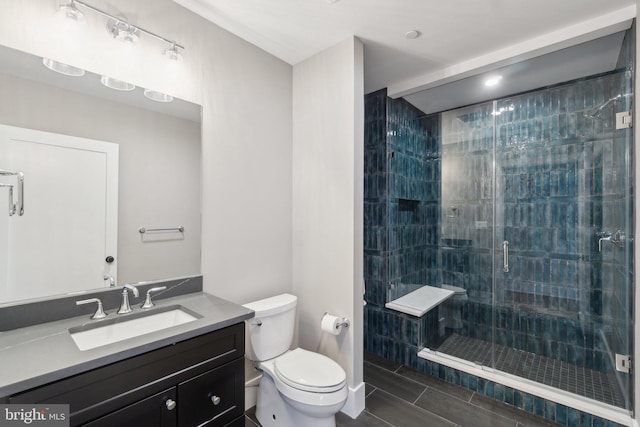 bathroom featuring toilet, an enclosed shower, vanity, and tile patterned flooring