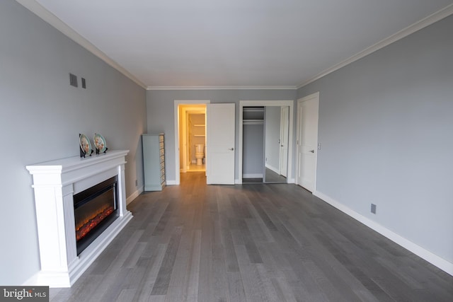 unfurnished living room featuring crown molding and dark hardwood / wood-style flooring