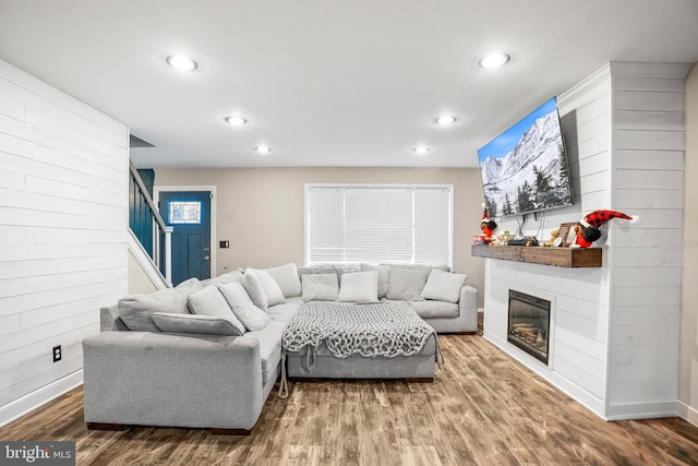 living room with wood walls and wood-type flooring