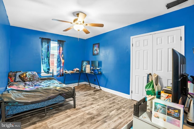 bedroom with hardwood / wood-style floors, a closet, and ceiling fan