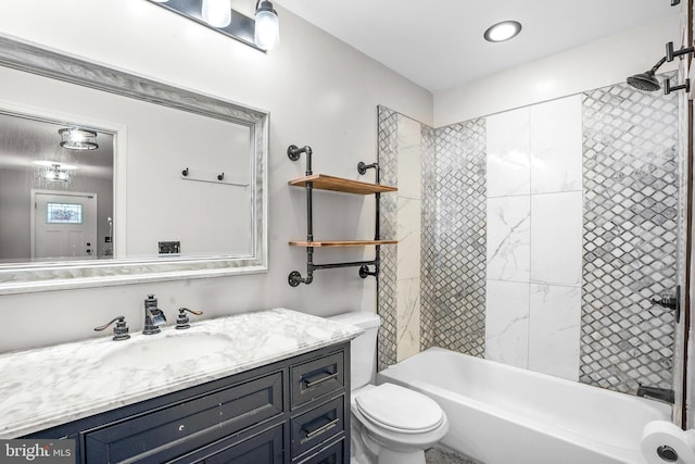 full bathroom featuring toilet, tiled shower / bath, and vanity