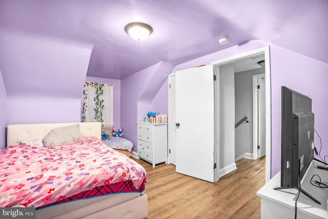 bedroom featuring lofted ceiling and hardwood / wood-style flooring