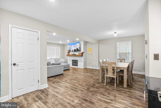 dining area featuring wood-type flooring and a fireplace