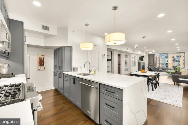 kitchen featuring appliances with stainless steel finishes, a sink, visible vents, and gray cabinetry