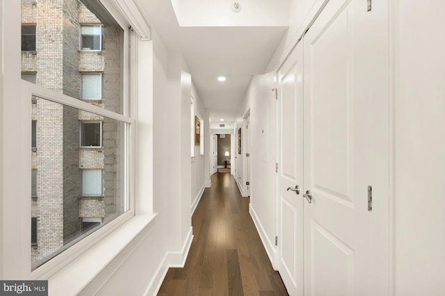 hall with dark wood-type flooring, recessed lighting, and baseboards