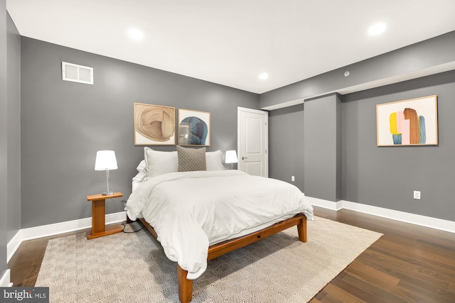 bedroom with dark wood-style floors, baseboards, and visible vents