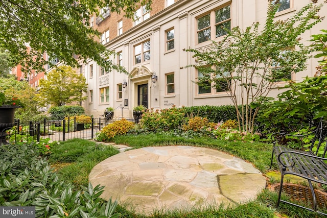 view of property's community featuring fence and a patio