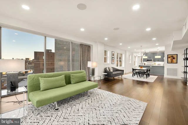 living area featuring recessed lighting, visible vents, baseboards, and wood finished floors