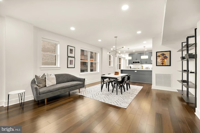 dining room with a notable chandelier, recessed lighting, visible vents, baseboards, and dark wood finished floors