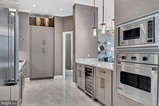 kitchen with gray cabinets, appliances with stainless steel finishes, beverage cooler, hanging light fixtures, and light stone countertops