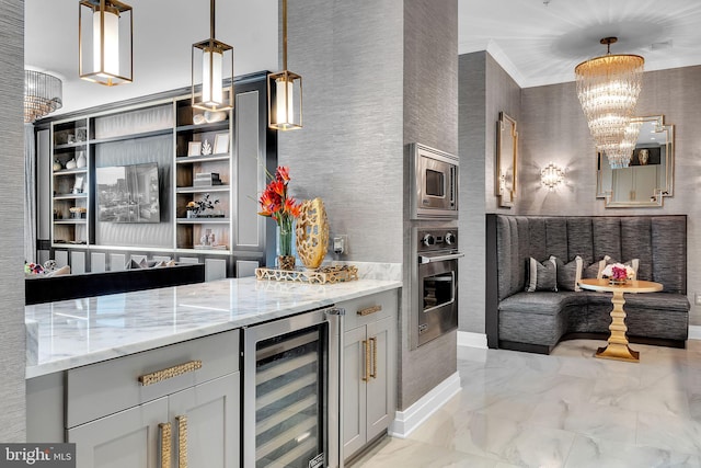 interior space featuring wine cooler, a chandelier, hanging light fixtures, stainless steel appliances, and light stone countertops