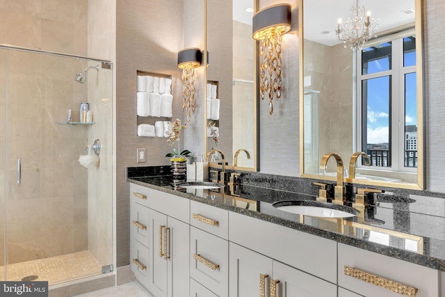 bathroom with vanity, a shower with shower door, and an inviting chandelier