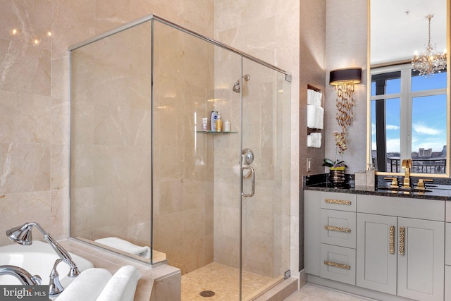 bathroom featuring vanity, separate shower and tub, and a notable chandelier