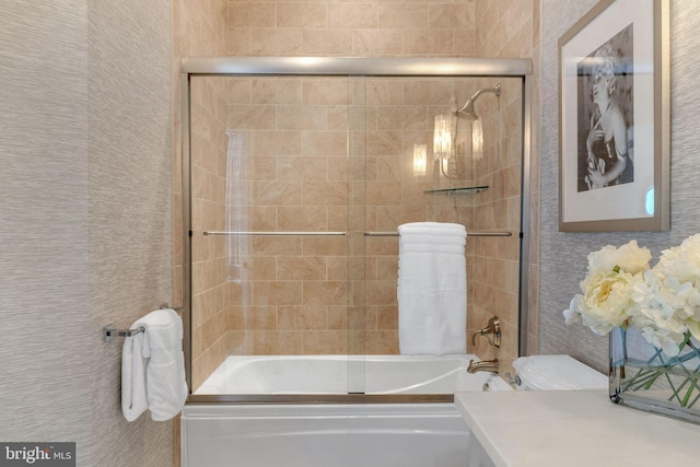 full bathroom featuring enclosed tub / shower combo, vanity, and toilet