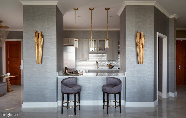 kitchen featuring built in refrigerator, kitchen peninsula, hanging light fixtures, and a breakfast bar area