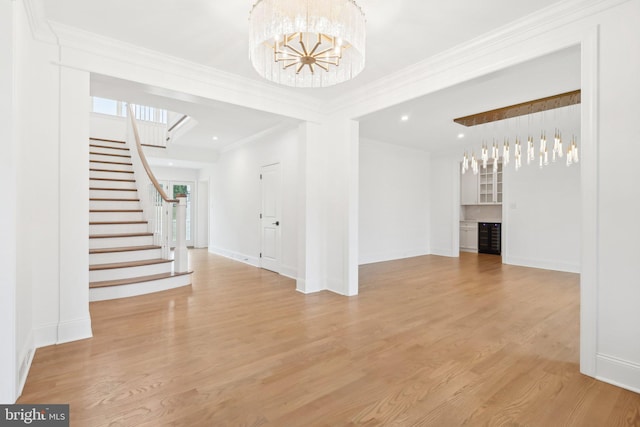 interior space featuring a chandelier, ornamental molding, and light hardwood / wood-style flooring