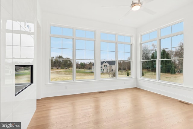 unfurnished sunroom with ceiling fan and plenty of natural light