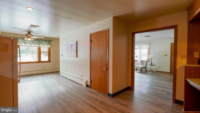 hallway with a baseboard radiator, dark hardwood / wood-style floors, and plenty of natural light