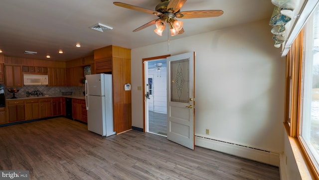 kitchen featuring white appliances, a baseboard radiator, light hardwood / wood-style floors, decorative backsplash, and ceiling fan