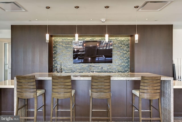 bar featuring dark brown cabinetry and decorative light fixtures