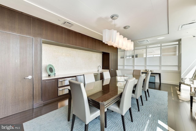 dining area featuring dark hardwood / wood-style floors and wood walls