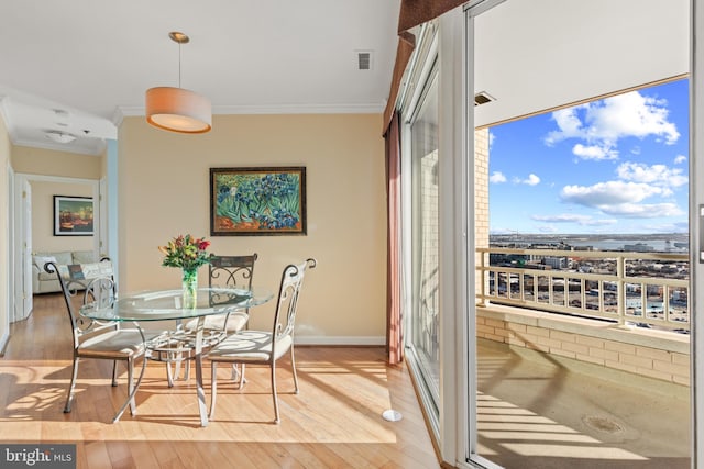 dining space with hardwood / wood-style flooring and ornamental molding