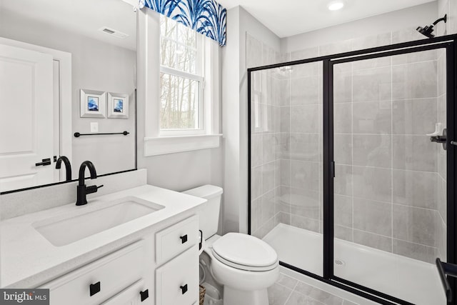 bathroom with walk in shower, tile patterned floors, vanity, and toilet