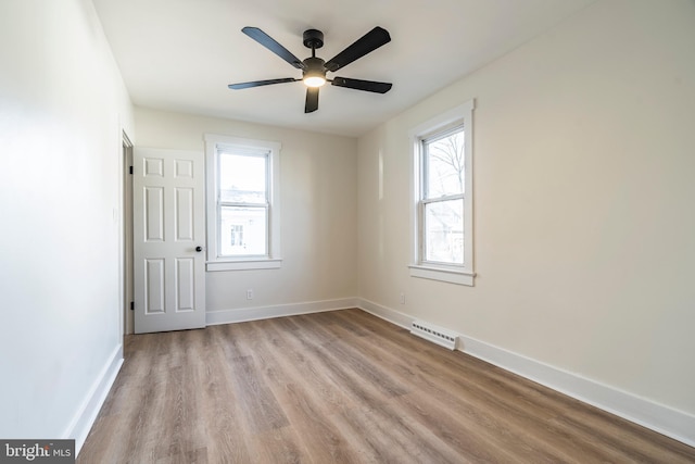 spare room with ceiling fan and light wood-type flooring