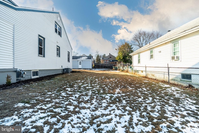 snowy yard featuring central air condition unit