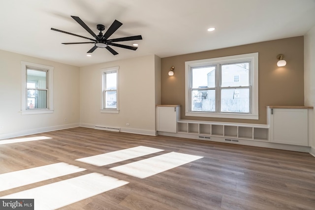 spare room with plenty of natural light, ceiling fan, and hardwood / wood-style floors