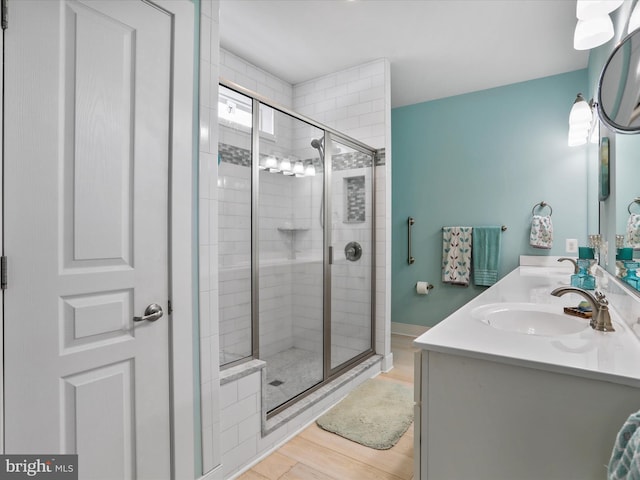 bathroom featuring a shower with door, hardwood / wood-style floors, and vanity