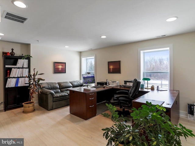 office space with a wealth of natural light and light hardwood / wood-style flooring