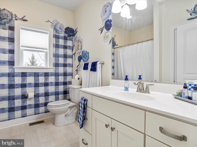 bathroom with toilet, hardwood / wood-style floors, and vanity