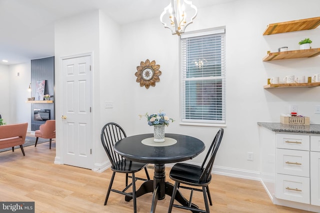 dining room with light wood-type flooring and a notable chandelier