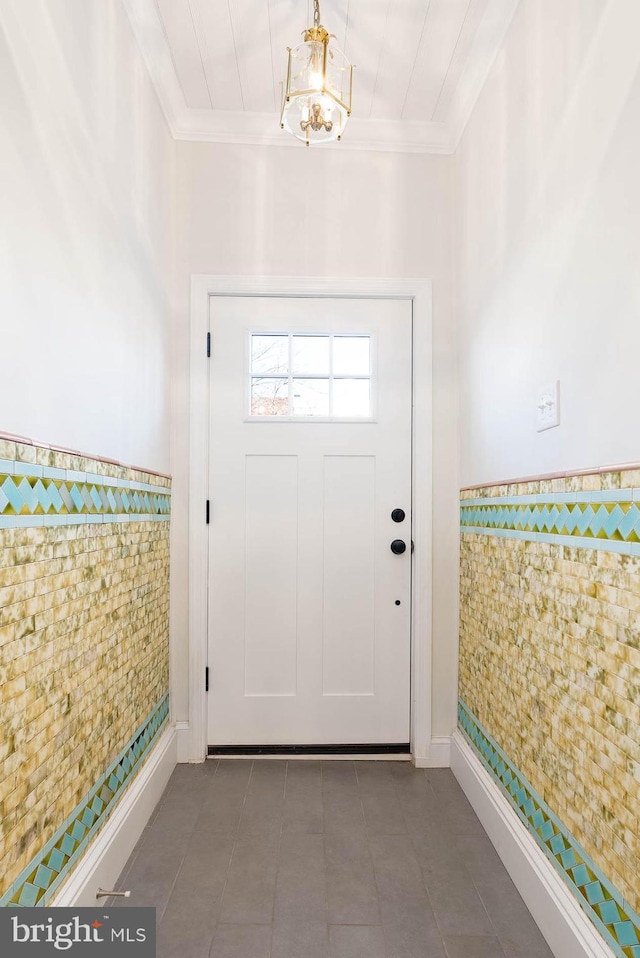 doorway with tile walls and crown molding