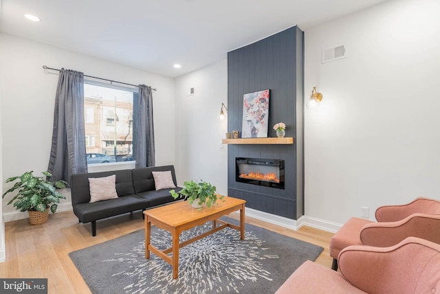 living room with a fireplace and light hardwood / wood-style flooring